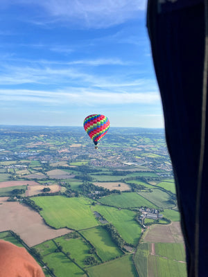 Colourful hot air balloon flying above Somerset countryside near Taunton