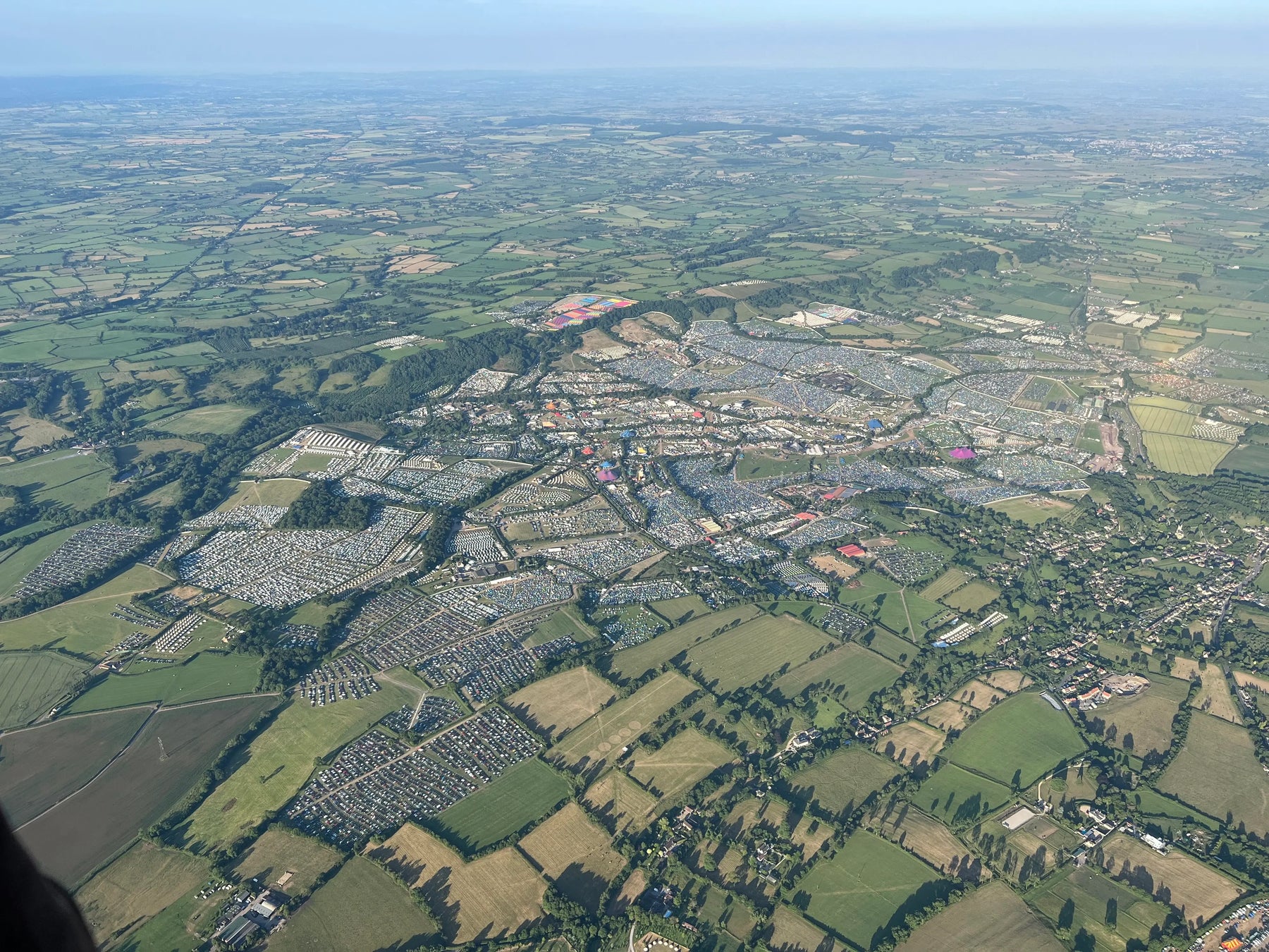Aerial view of Glastonbury Festival site and surrounding Somerset countryside seen from a hot air balloon