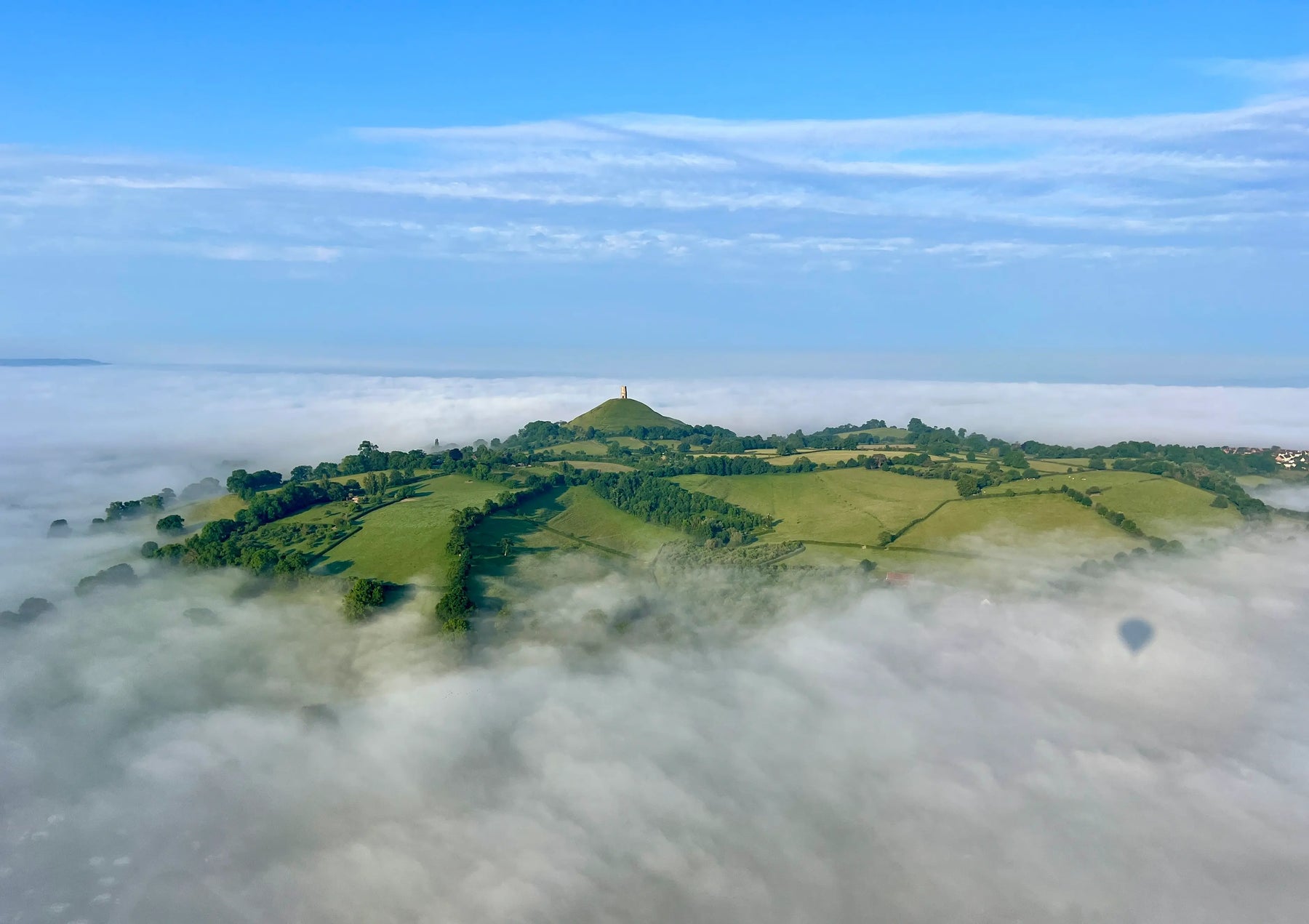 Glastonbury Tor rising above a cloud inversion seen from a hot air balloon flight
