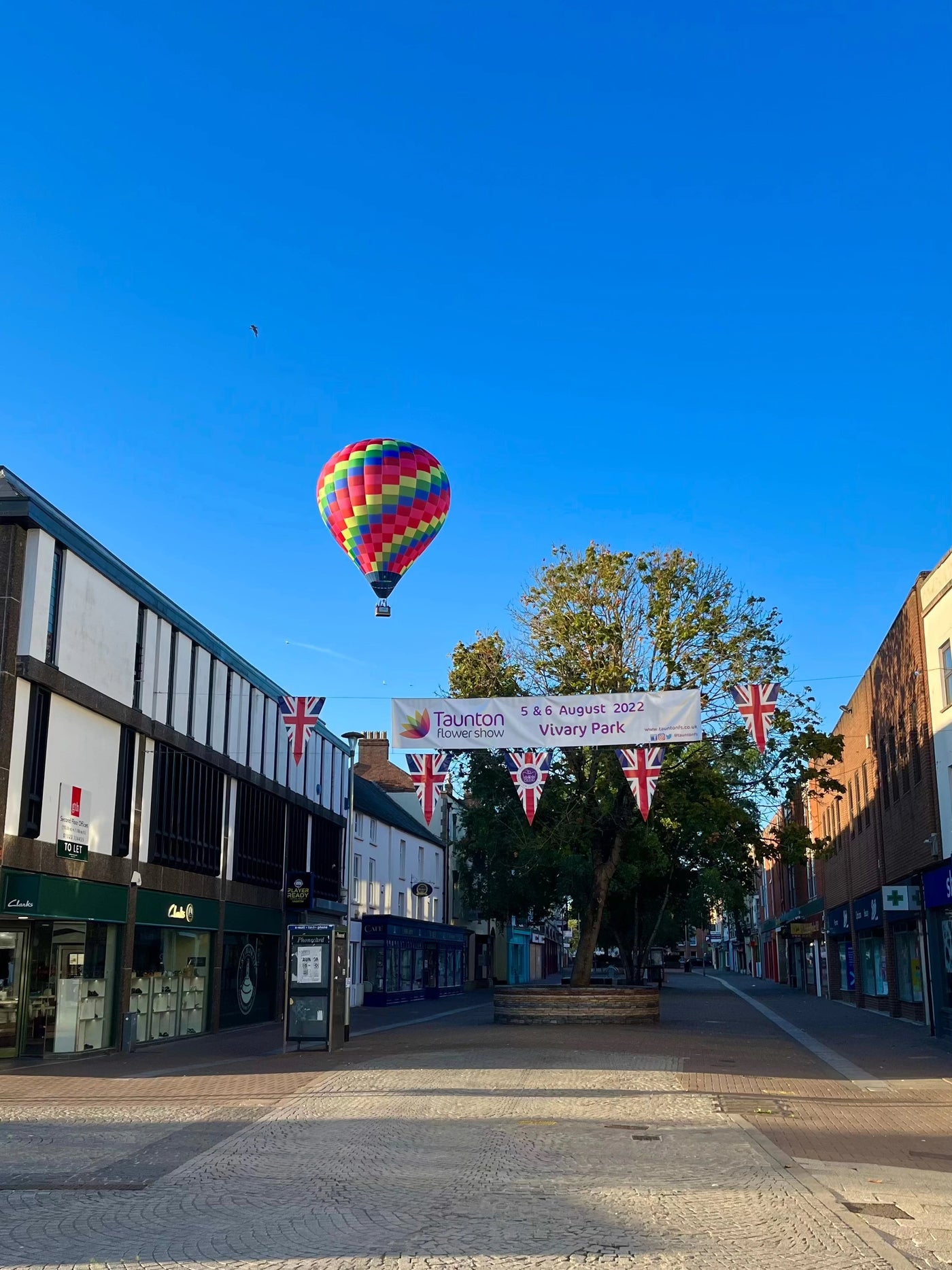 Colourful hot air balloon flying above Taunton town centre near Vivary Park in Somerset