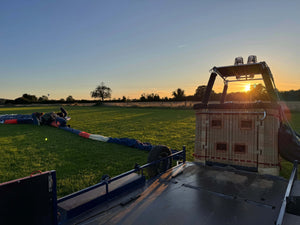 Hot air balloon basket and envelope being prepared in a field near Wells Somerset at sunset