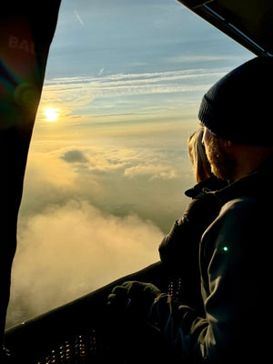 Passengers enjoying sunrise above a cloud inversion during a hot air balloon flight in Devon