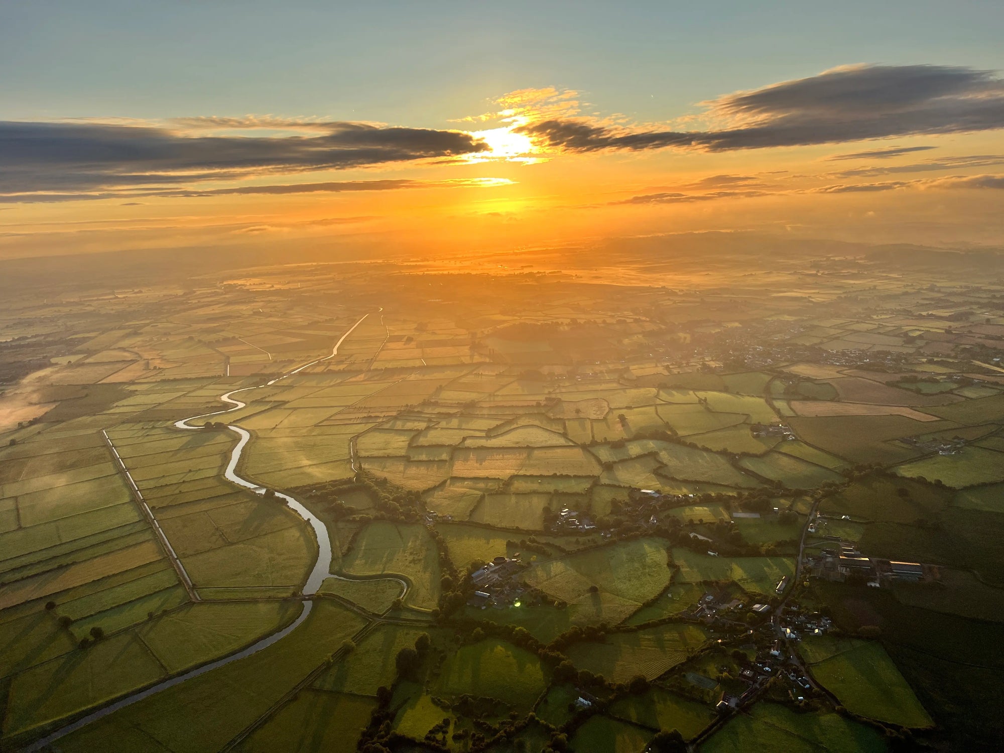 Sunrise over the Somerset Levels with winding river and farmland seen from a hot air balloon Taunton