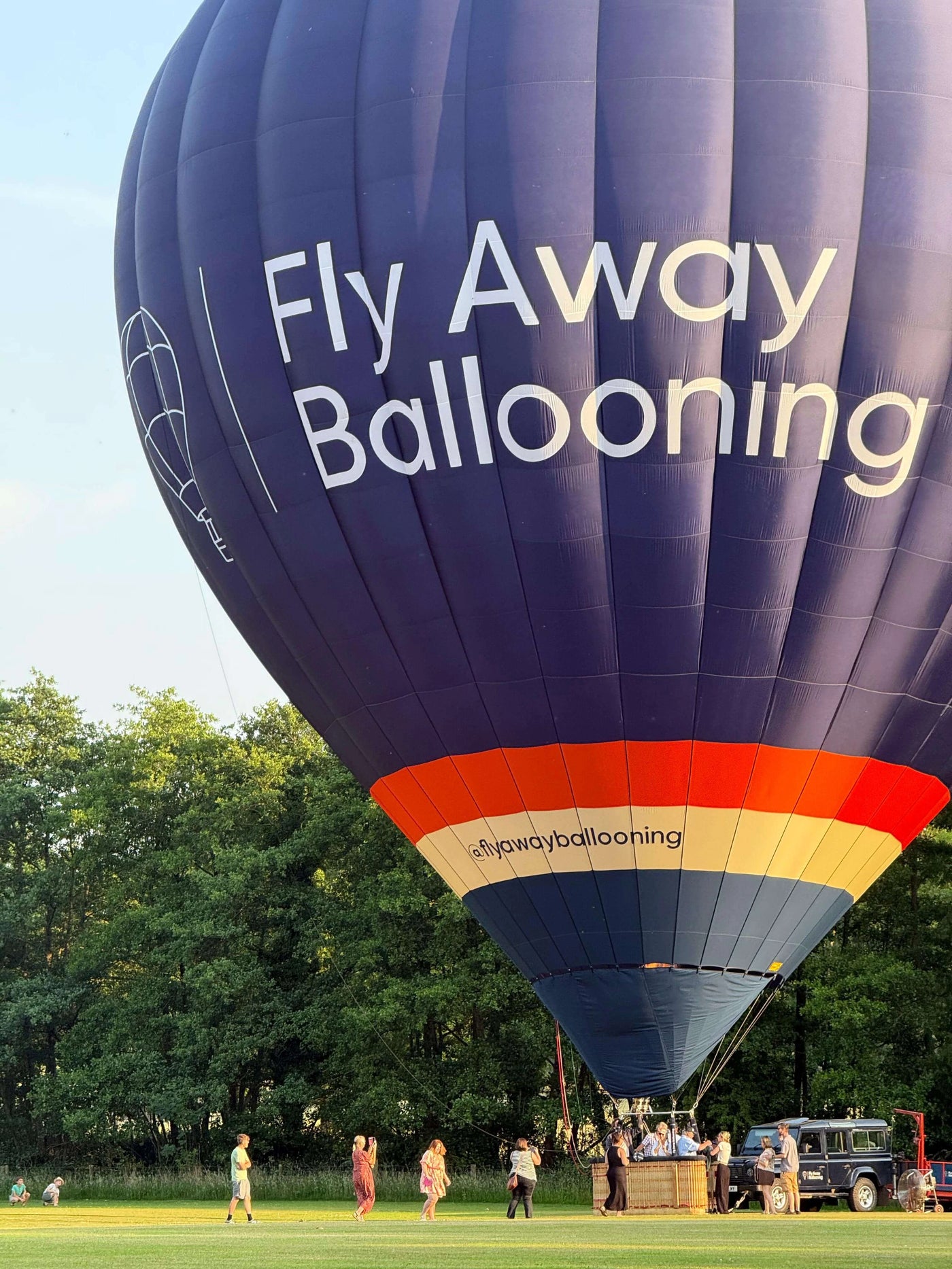 Fly Away Ballooning hot air balloon preparing for launch in a field near Wells Somerset with passengers nearby